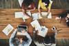 An aerial view of five colleagues in an office team meeting