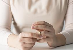 An anonymous woman removes her wedding ring